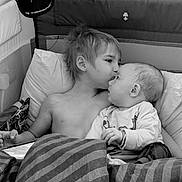Tylan joined the competition — help win amazing prizes! child, baby, kiss, crib, blanket, pillow, bedroom, cuddle, infant, sibling, love, comfort, black_and_white, shirtless, portrait, indoor, cute, family, toddler, rest