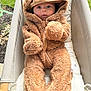 baby, infant, child, costume, plush, outdoor, chair, fabric, cute, face, hood, clothing, seated, expression, person, fur, soft, warm, curious, cushion