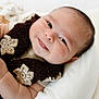 Aiden joined the competition — help win amazing prizes! baby, infant, smile, face, knitted_scarf, flower_pattern, cozy, cute, soft, white_background, portrait, child, skin, happy, closeup, newborn, laying_down, expression, warm, candid