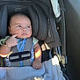 baby, car_seat, infant, child, blanket, seatbelt, sitting, indoors, clothing, bracelet, head_support, cute, thoughtful, portrait, soft_light, baby_girl, car_interior, closeup, expression, safety
