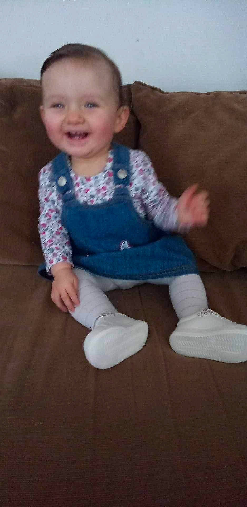 Léna participe au concours pour gagner de l'argent avec cette photo : baby_toddler_clothing, cheek, comfort, couch, eye, face, finger, floor, flooring, head, iris, joy, leg, nose, person, skin, sleeve, smile, sock, standing