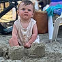 beach, blue_eyes, blurred_background, child, clothing, curious, expression, face, hair, outdoor, person, play, sand, sandcastle, sitting, skin, summer, sunlight, toddler, vacation