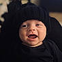 baby, infant, child, smiling, happy, black_hat, knit_hat, black_clothing, portrait, cute, face, mouth_open, eyes, headwear, indoors, warm, cozy, closeup, person, expression