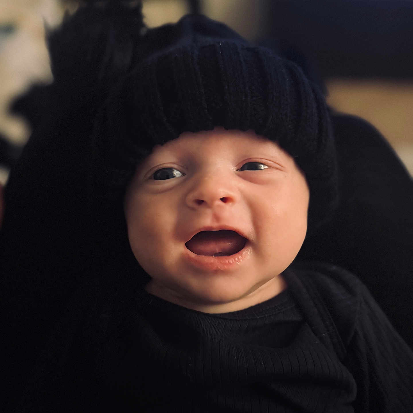 Koby joined the competition — help win amazing prizes! baby, black_clothing, black_hat, child, closeup, cozy, cute, expression, eyes, face, happy, headwear, indoors, infant, knit_hat, mouth_open, person, portrait, smiling, warm