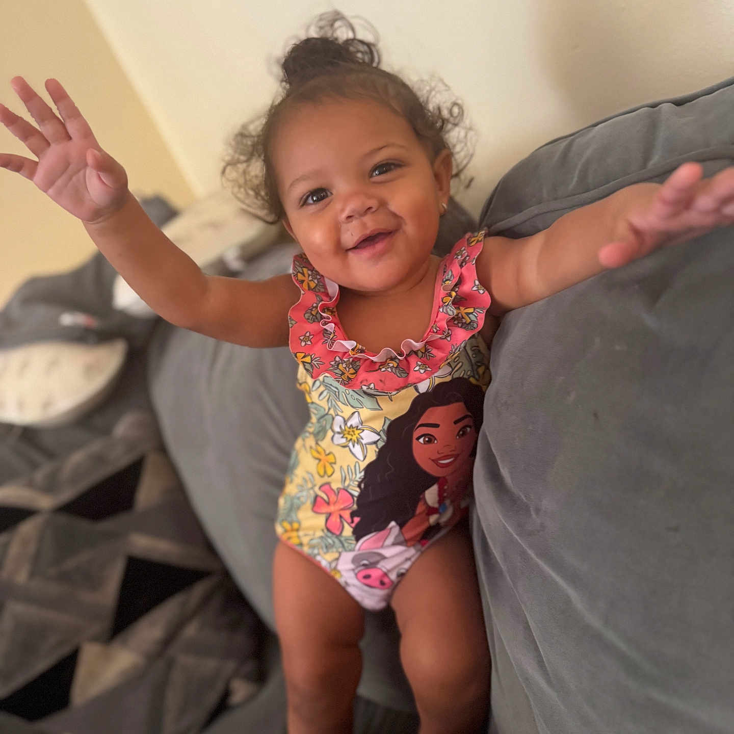 Alauni joined the competition — help win amazing prizes! arms_outstretched, cartoon_character, child, couch, curly_hair, cushion, cute, fun, happy, home, indoor, person, playful, plush, portrait, relaxed, smiling, swimsuit, toddler, young_child