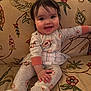 Amelia joined the competition — help win amazing prizes! baby, child, smiling, pajamas, bow, hair_accessory, sitting, couch, floral_pattern, indoor, cute, happy, person, toddler, home, cozy, infant, fabric, comfort, portrait