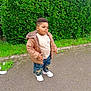 boy, casual_clothing, child, cute, daylight, fashion, greenery, hedge, jacket, jeans, nature, outdoor, pavement, portrait, short_hair, sneakers, standing, toddler, urban, young_person