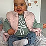 Victoire participe au concours pour gagner de l'argent avec cette photo : baby, child, smiling, headband, pink_vest, green_sweater, denim_jeans, white_socks, cushion, patterned_bedding, teddy_bear_wall_decor, stars_wall_decor, indoor, cute, happy, portrait, seated, infant, head, clothing