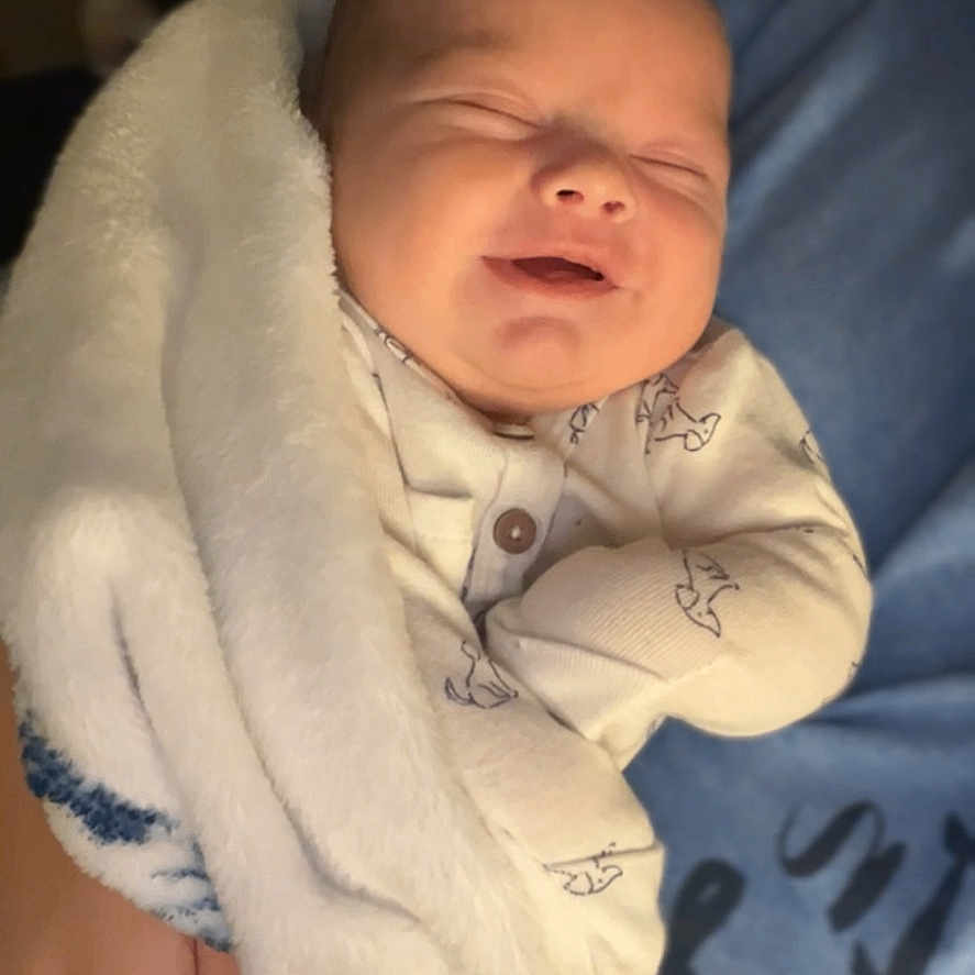Elijah is registered to the contest to win money with this photo: baby, blanket, child, clothing, comfort, cozy, cute, hand, indoors, infant, newborn, peaceful, person, portrait, sleeping, smiling, soft, toddler, warm, wrapped