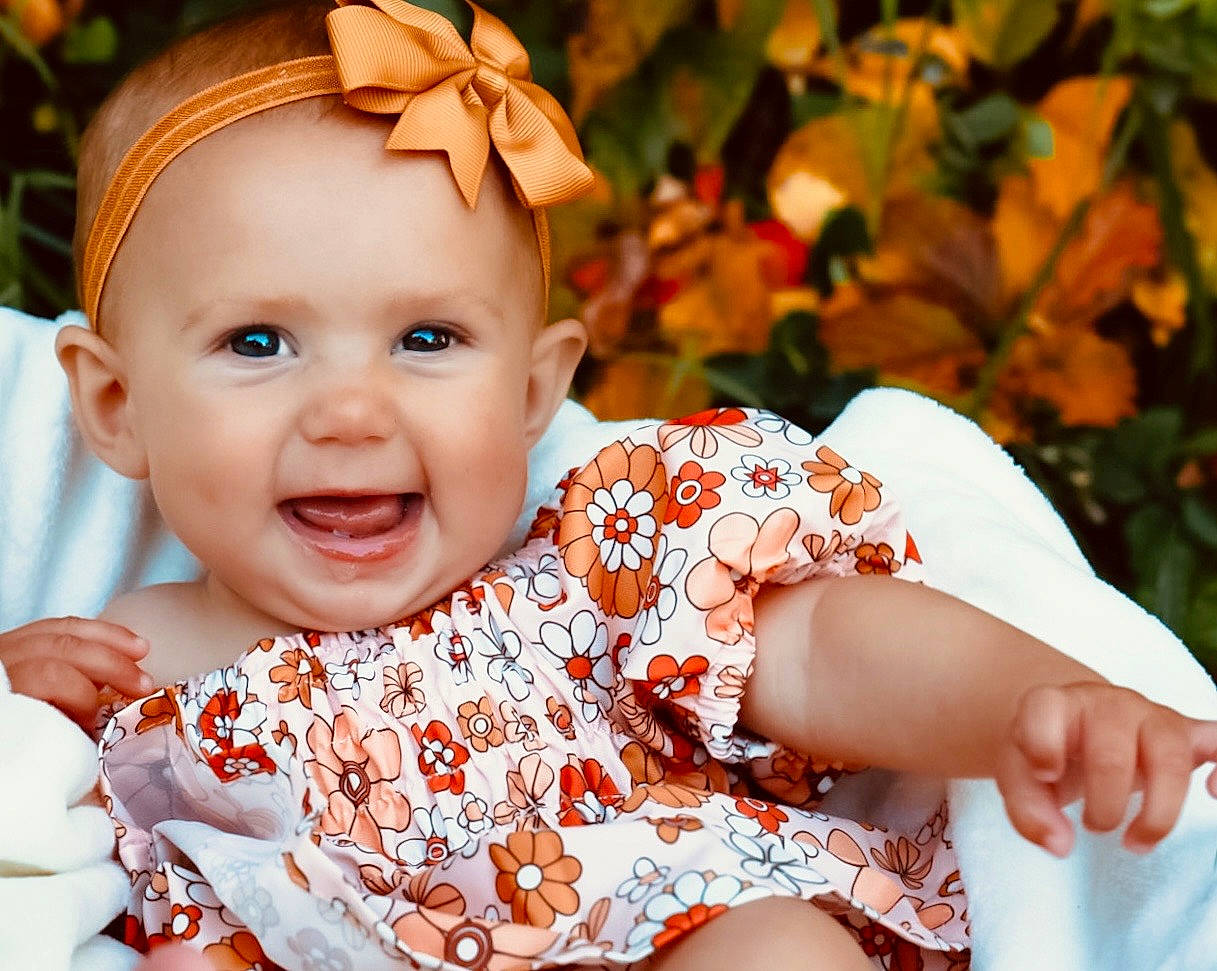 Hailyn is registered to the contest to win money with this photo: baby, baby_toddler_clothing, child, dress, event, flash_photography, fun, grass, happy, joy, orange, pattern, peach, people_in_nature, person, portrait_photography, sitting, skin, sleeve, smile