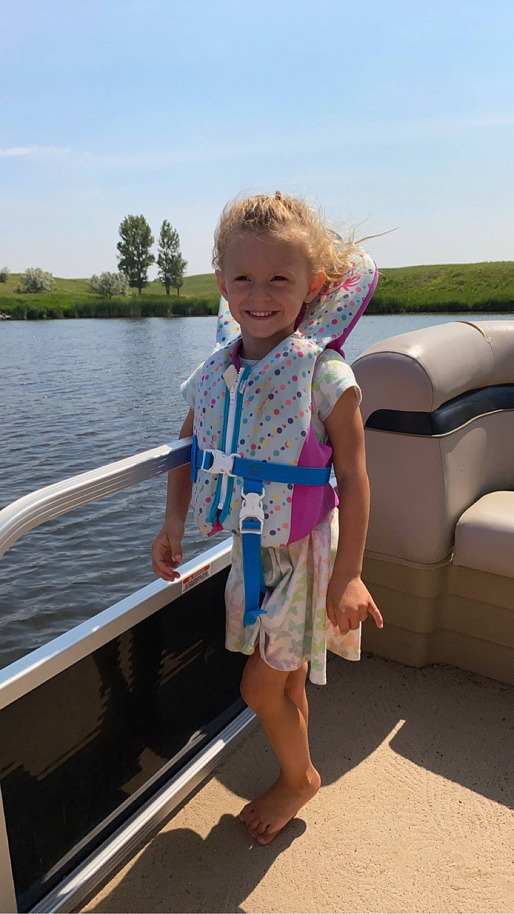 Anna is registered to the contest to win money with this photo: boat, boats_and_boating_equipment_and_supplies, child, fun, joy, lake, leisure, outdoor_recreation, person, personal_protective_equipment, recreation, sandal, sky, smile, summer, toddler, travel, tree, vacation, water