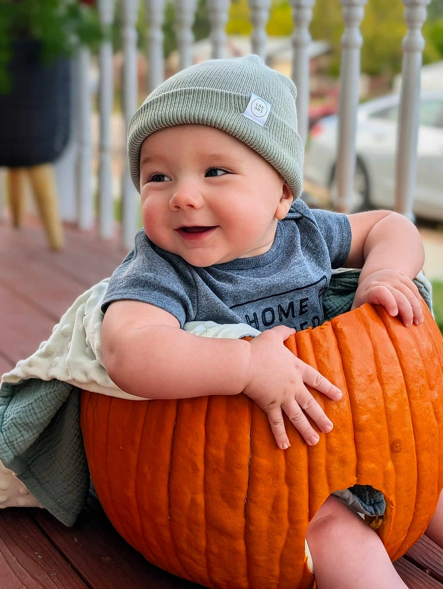 Skyler joined the competition — help win amazing prizes! baby, child, pumpkin, hat, smiling, autumn, porch, blanket, cute, happy, orange, seasonal, cozy, outdoor, person, infant, clothing, face, headwear, playful