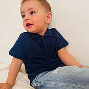 Lucas Lixandroiu is registered to the contest to win money with this photo: child, toddler, boy, portrait, indoors, white_wall, navy_shirt, jeans, sitting, spiky_hair, expressive_eyes, looking_away, hand, ear, bed, casual_clothing, cute, candid, skin, playful_expression