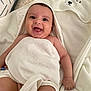 baby, smiling, towel, hood, bunny_ears, happy, infant, skin, tongue_out, blanket, cute, lying_down, comfort, indoors, child, closeup, person, soft_texture, pillow, white