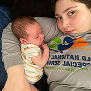 Asher is registered to the contest to win money with this photo: baby, newborn, adult, person, face, closeup, lying_down, holding, onesie, striped_clothing, pacifier, blanket, home, comfort, intimate, tender, casual_clothing, portrait, skin, relaxation