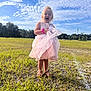 Olivia is registered to the contest to win money with this photo: child, girl, dress, pink, grass, outdoor, field, sky, clouds, sunlight, happy, laughing, footwear, sandals, nature, summer, playful, person, smile, daytime