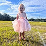 Olivia is registered to the contest to win money with this photo: child, girl, pink_dress, outdoor, grass, field, sky, clouds, sunlight, footwear, sandals, nature, portrait, standing, curly_hair, greenery, daylight, casual, happy, person