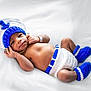 Kairo is registered to the contest to win money with this photo: baby, newborn, infant, crochet, hat, booties, diaper_cover, blue, white, lying_down, soft_surface, cute, portrait, child, newborn_baby, hand_near_face, peaceful, indoors, cozy, clothing