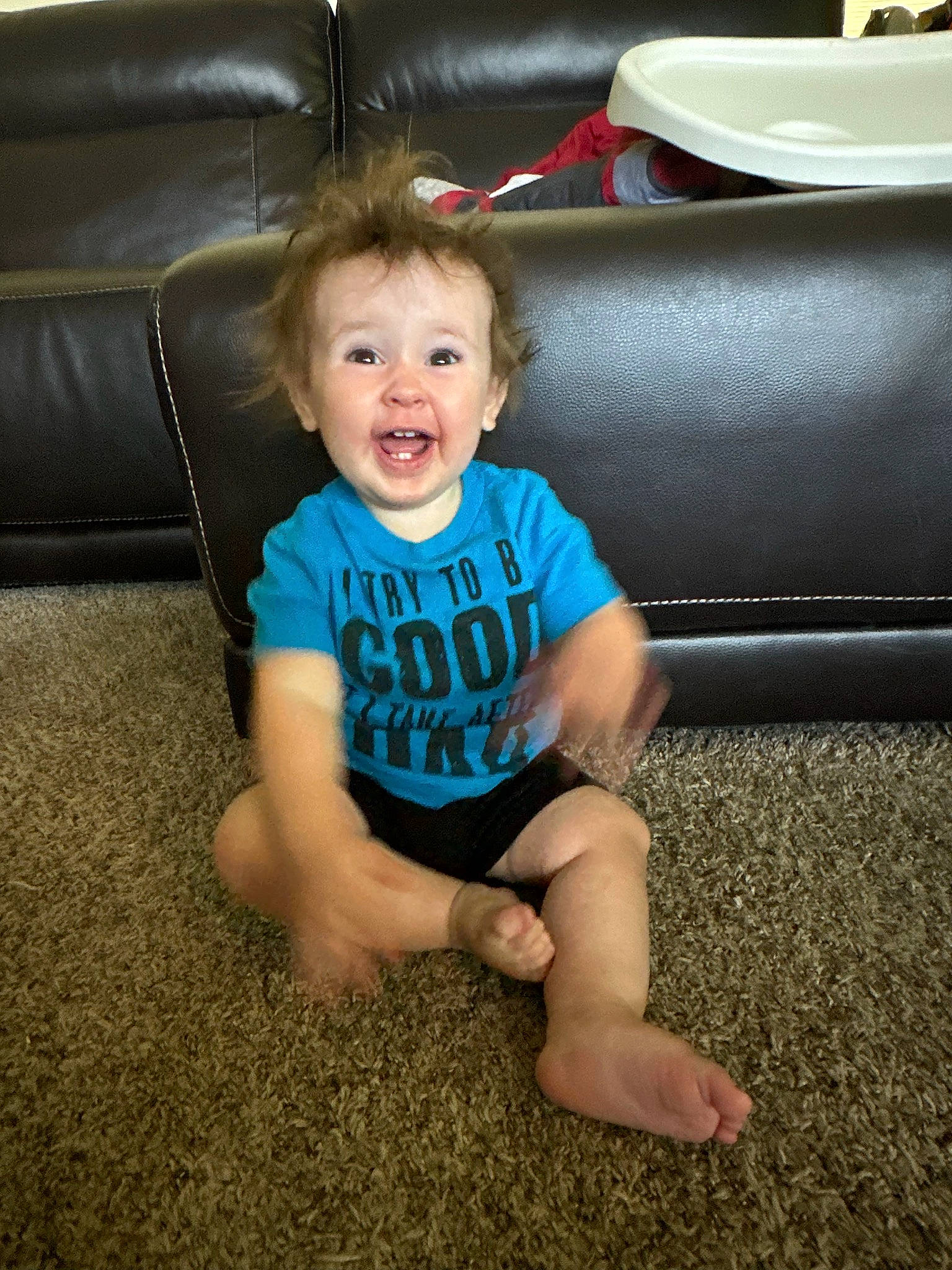 Ryker is registered to the contest to win money with this photo: child, comfort, couch, electric_blue, flash_photography, floor, flooring, foot, fun, happy, human_leg, knee, lap, living_room, person, sitting, smile, t_shirt, thigh, toddler
