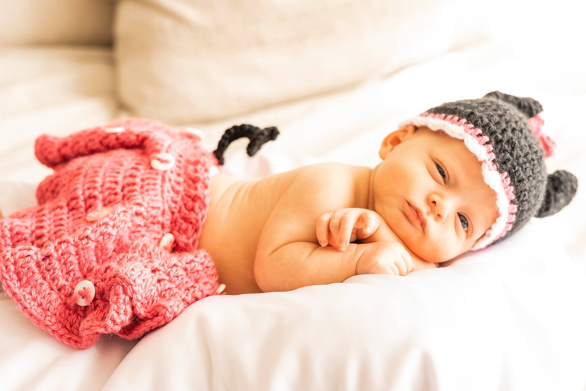 Oakley is registered to the contest to win money with this photo: arm, baby, baby_sleeping, baby_toddler_clothing, comfort, couch, eyelash, fashion_accessory, flash_photography, hand, happy, headpiece, headwear, jewellery, knit_cap, linens, lip, pattern, person, skin