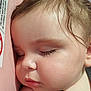 baby, car_seat, child, close_up, cute, eyelashes, face, hair, indoors, infant, peaceful, pink_background, portrait, resting, safety_label, seatbelt, skin, sleeping, soft_light, toddler