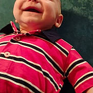 Sylas joined the competition — help win amazing prizes! baby, smiling, child, striped_shirt, pink_clothing, navy_blue, happy, lying_down, infant, closeup, face, human, cute, young_child, buttoned_shirt, short_sleeves, skin, hand, indoors, fabric