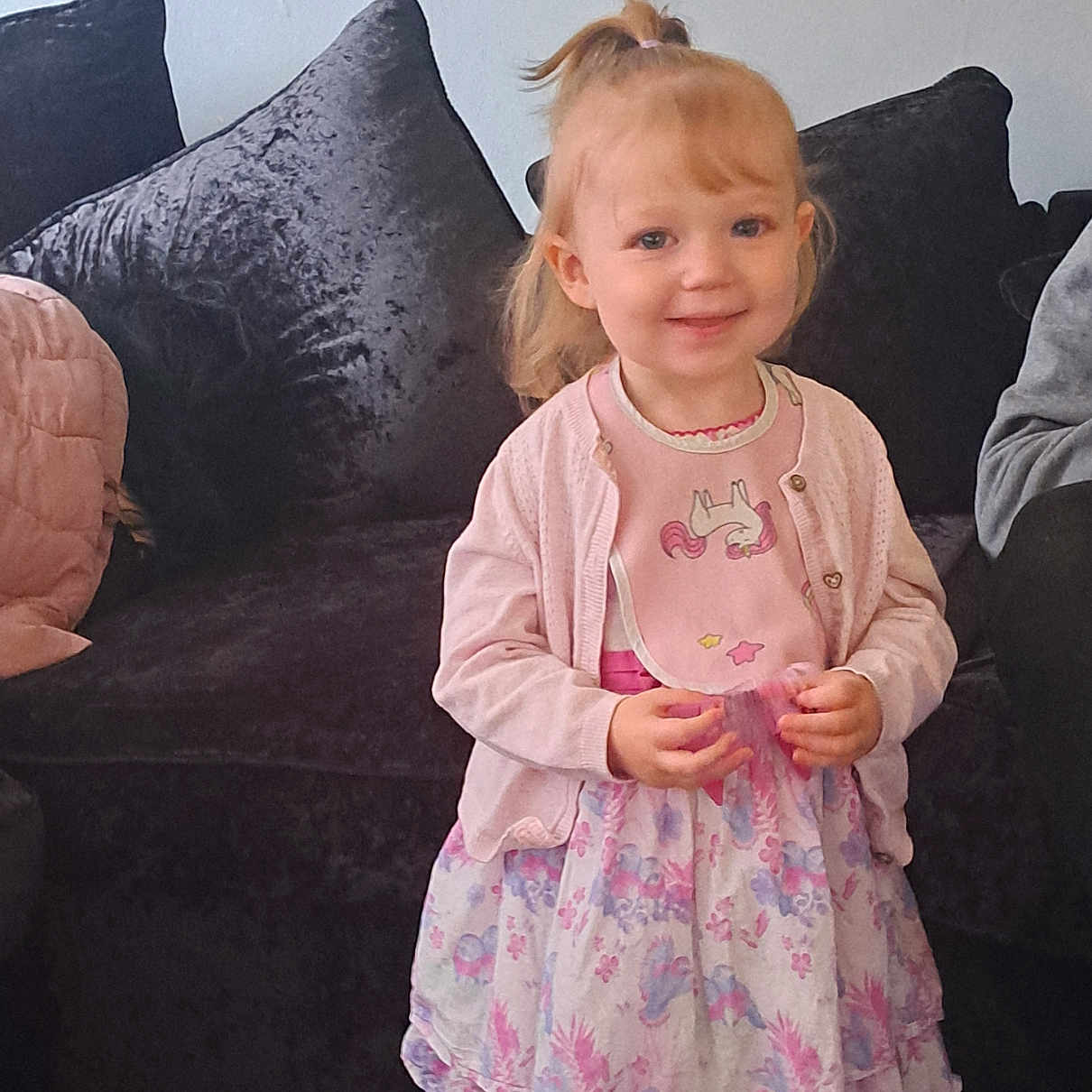 Nala-mai joined the competition — help win amazing prizes! bib, carpet, child, clothing, couch, cute, dress, floral, girl, happy, indoors, person, pillow, pink, pony_tail, smile, standing, toddler, unicorn, young