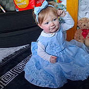 Nala-mai joined the competition — help win amazing prizes! toddler, child, dress, blue_dress, headband, carpet, teddy_bear, toy, indoor, curly_hair, sitting, patterned_rug, cute, playful, smiling, furniture, home, decor, person, portrait