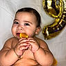 Liam Infante is registered to the contest to win money with this photo: baby, child, orange_slice, juice, hands, chubby, smiling, balloon, number_balloon, golden_balloon, bare_skin, cuteness, portrait, happy, close_up, face, infant, sitting, food, background