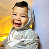 toddler, child, smiling, hoodie, gray_clothing, happy, face, portrait, indoor, warm_light, person, cute, baby, sitting, cozy, young_child, casual_wear, headwear, expression, closeup