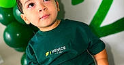 Liam Infante joined the competition — help win amazing prizes! balloons, birthday, celebration, child, curly_hair, cute, decorations, eyes, face, fuzzy_stool, green_clothing, happy, indoor, number_two, person, portrait, shorts, sitting, toddler, tshirt