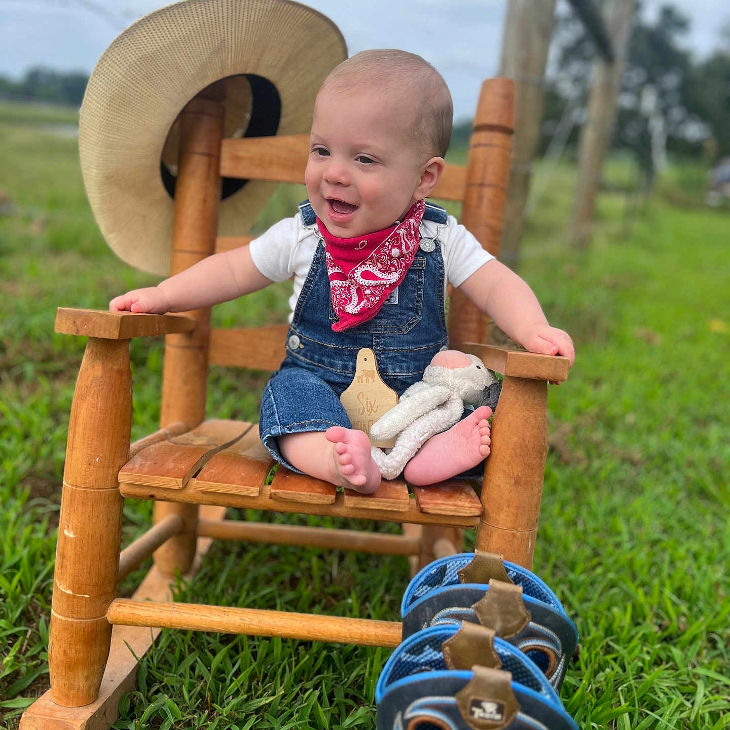 Lane joined the competition — help win amazing prizes! baby, bandana, child, countryside, cowboy_boots, denim_overalls, feet, footwear, grass, happy, hat, nature, outdoor, person, plush_toy, portrait, rocking_chair, smiling, toy, wood