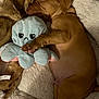 puppy, sleeping, stuffed_toy, octopus, blanket, fur, cozy, pet, cute, animal, nap, brown_puppy, soft_toy, indoors, rest, fur_texture, snuggling, peaceful, young_dog, pet_bed