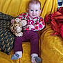 Olivia participe au concours pour gagner de l'argent avec cette photo : baby, child, plush_toy, tiger_toy, yellow_blanket, pillow, purple_pants, floral_shirt, smiling, blue_eyes, sitting, cozy, indoors, soft_texture, cute, happy, person, sock, fabric, home