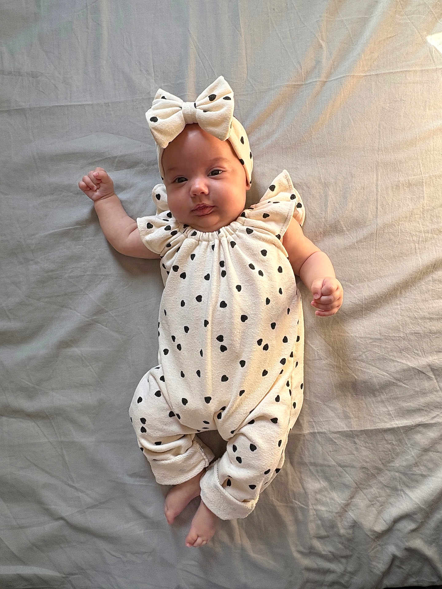 Serena a rejoint le concours — aidez-le/la à gagner de superbes lots ! baby, infant, polka_dot, headband, bow, onesie, lying_down, blanket, cute, child, soft_lighting, indoor, portrait, small_hands, footwear_free, comfortable, adorable, neutral_background, sleepwear, smiling