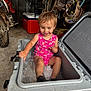 toddler, child, cooler, ice, garage, motorcycle, tools, pink_clothing, smiling, sitting, playful, concrete_floor, storage, casual, indoor, happy, short_hair, cute, person, container