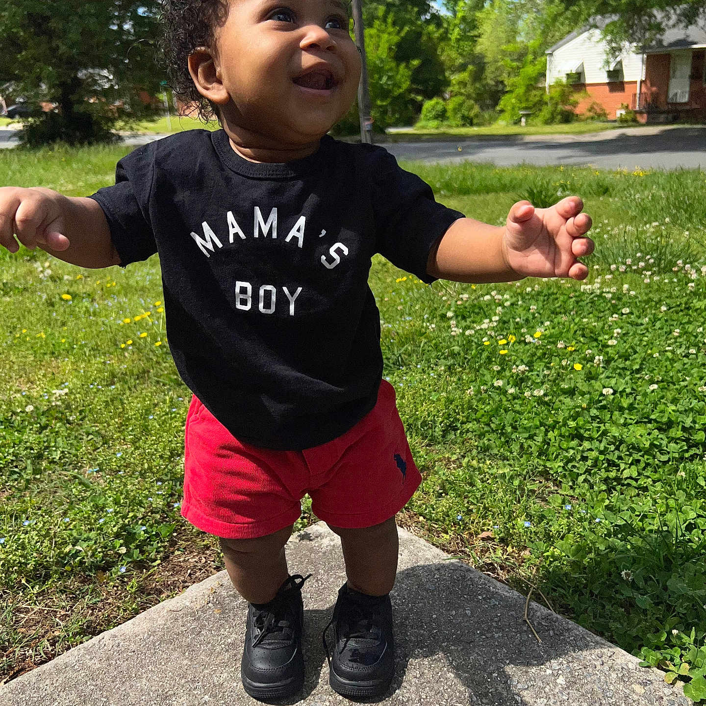 Wynton is registered to the contest to win money with this photo: bodypart, clothing, face, finger, footwear, grass, hand, head, nature, outdoors, park, person, photography, plant, portrait, shoe, shorts, summer, t_shirt, vegetation