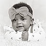 adorable, baby, black_and_white, bow, child, close_up, clothing, cute, eyes, face, fluffy_surface, hand, headband, heart_pattern, infant, lying_down, portrait, skin, smile, young
