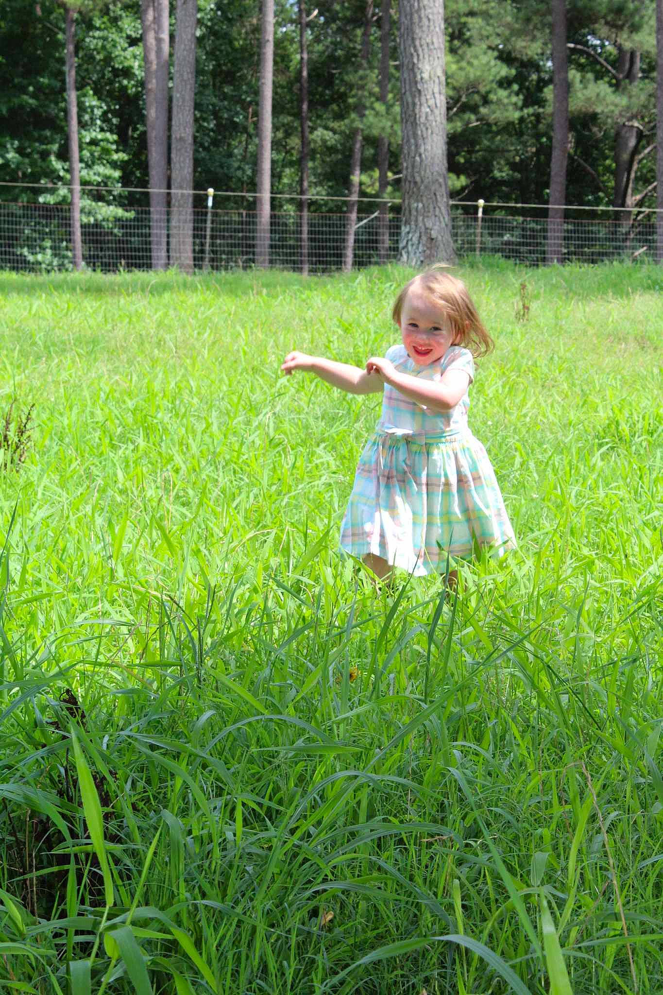 Riley is registered to the contest to win money with this photo: baby_toddler_clothing, child, dress, fun, grass, grassland, groundcover, happy, joy, lawn, meadow, natural_environment, natural_landscape, pasture, people_in_nature, person, plant, prairie, recreation, terrestrial_plant