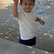 Cruz joined the competition — help win amazing prizes! child, boy, smiling, waving, outdoor, daylight, shade, concrete, sculpture, playground, casual_clothing, white_shirt, shorts, happy, portrait, person, young, curly_hair, park, nature