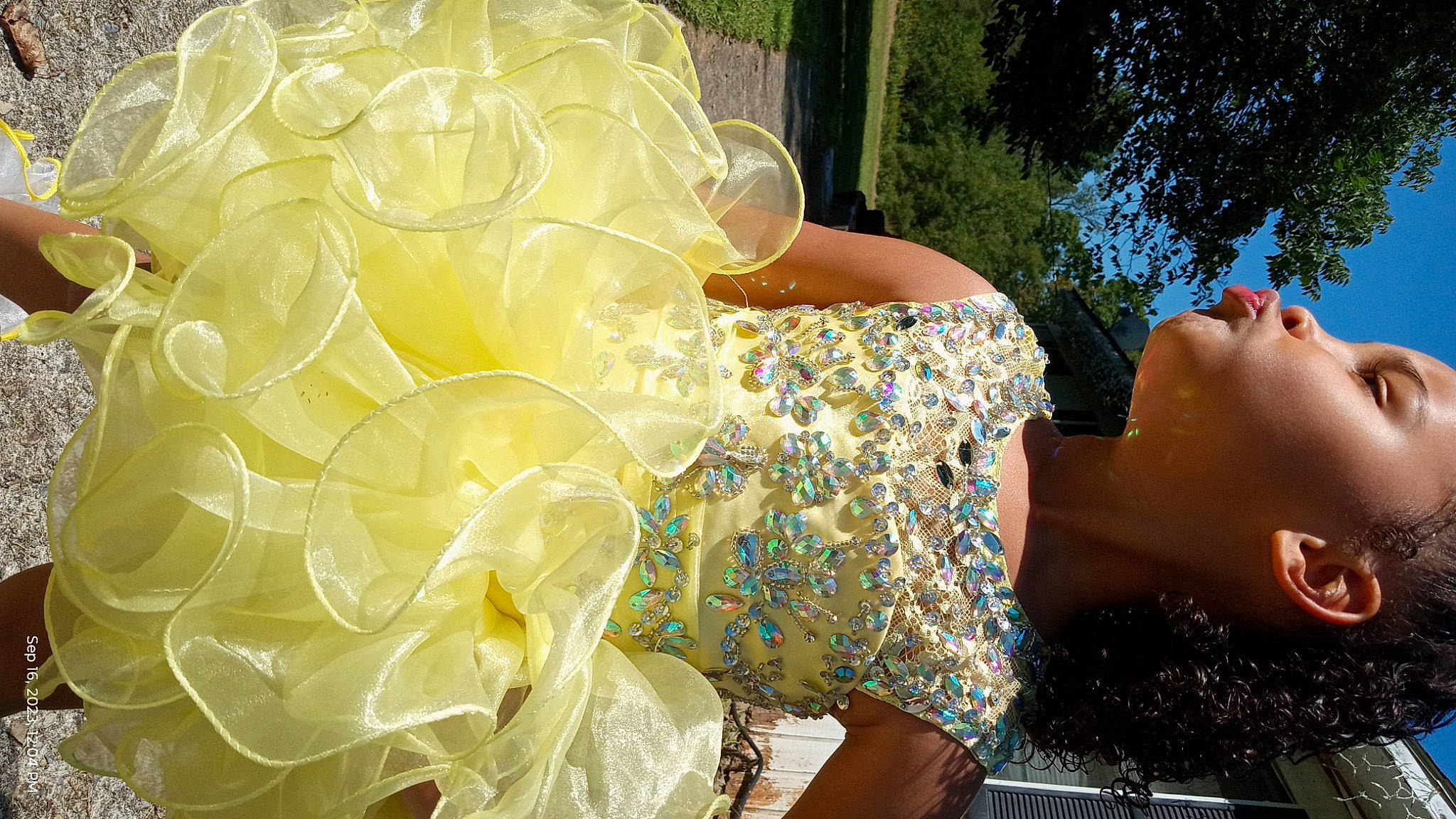 Jayla is registered to the contest to win money with this photo: bouquet, bridal_accessory, bridal_clothing, child, cut_flowers, dress, event, eyewear, fashion_accessory, fun, grass, happy, headpiece, human_leg, leisure, party_supply, person, plant, sunglasses, tree