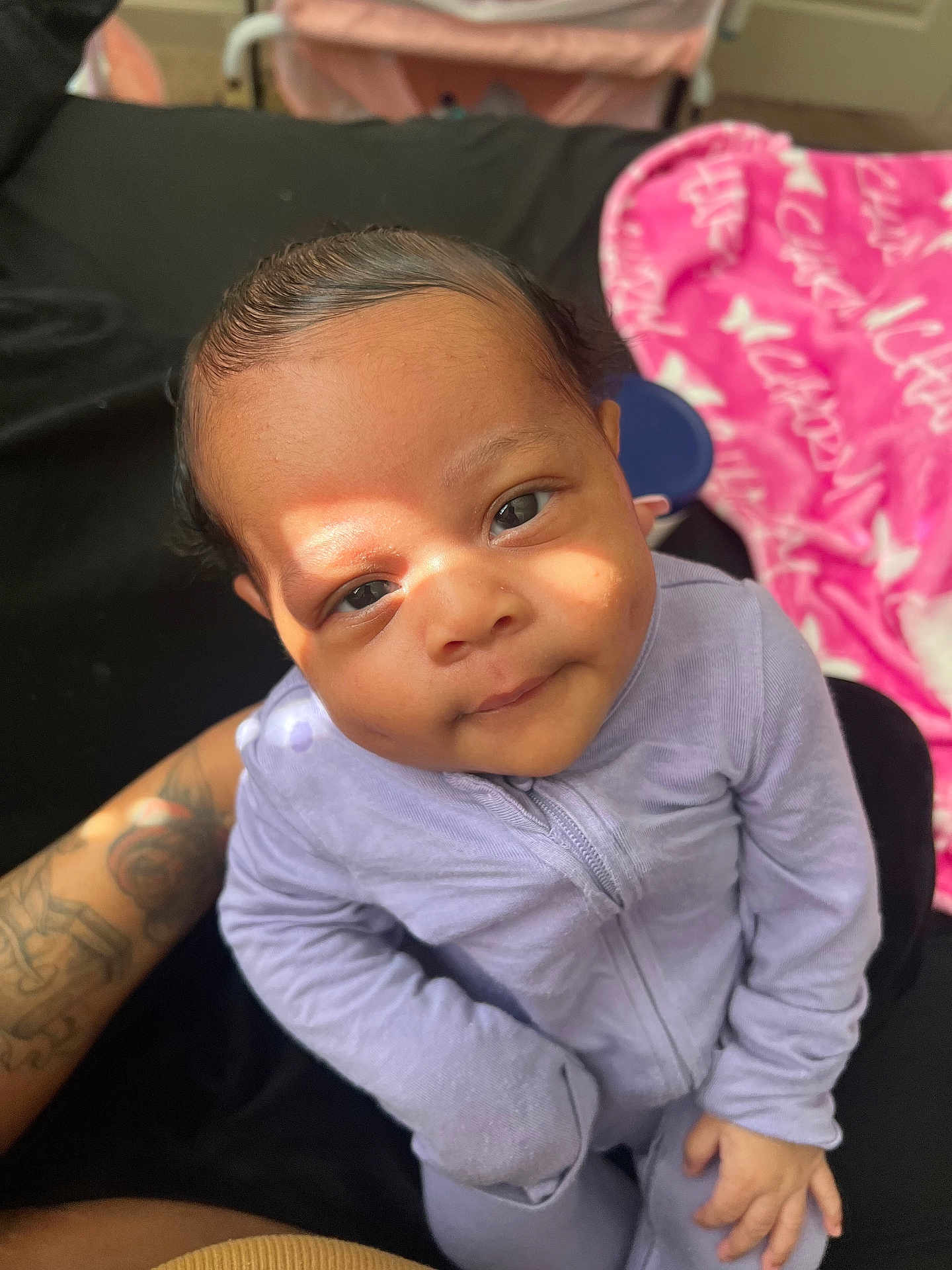 Charm joined the competition — help win amazing prizes! baby, infant, child, onesie, purple_clothing, tattoo, arm, face, eyes, hand, fingers, blanket, pink_blanket, black_fabric, indoor, portrait, sunlight, shadow, cute, cozy