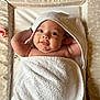 baby, towel, infant, smile, face, skin, hand, blanket, hooded_towel, changing_mat, star_pattern, cute, lying_down, child, newborn, happy, indoors, person, soft_texture, playful