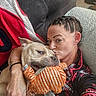 Mack joined the competition — help win amazing prizes! blanket, braided_hair, casual_clothing, companion, couch, cozy, cuddle, dog, indoor, kiss, nose_ring, orange, person, pet, plush_toy, portrait, sleepy, striped_toy, tattoo, woman