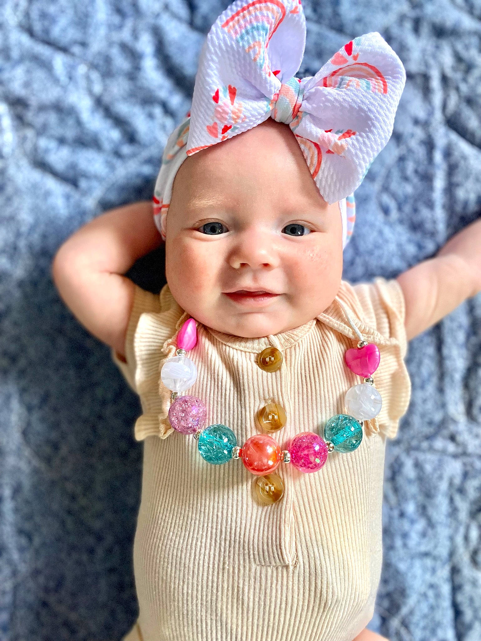 Khloe is registered to the contest to win money with this photo: baby, baby_toddler_clothing, cap, child, costume_hat, eye, face, finger, gesture, hand, happy, headwear, jewellery, magenta, pattern, person, pink, sleeve, textile, thumb