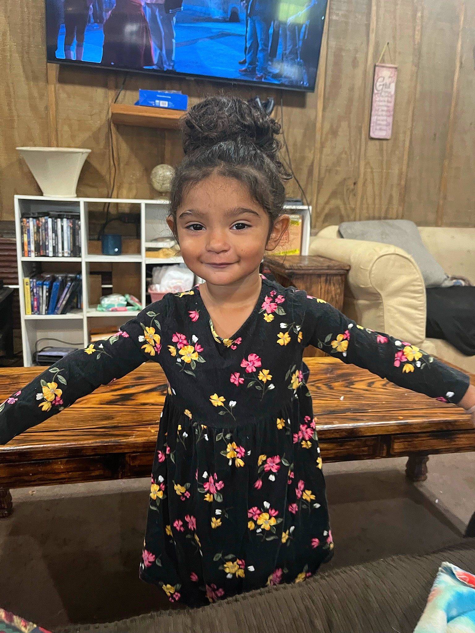 Topanga is registered to the contest to win money with this photo: bookcase, chair, child, couch, fashion_design, fun, indoor_games_and_sports, joy, led_backlit_lcd_display, leisure, person, picture_frame, play, recreation, room, shelf, sitting, sleeve, smile, t_shirt