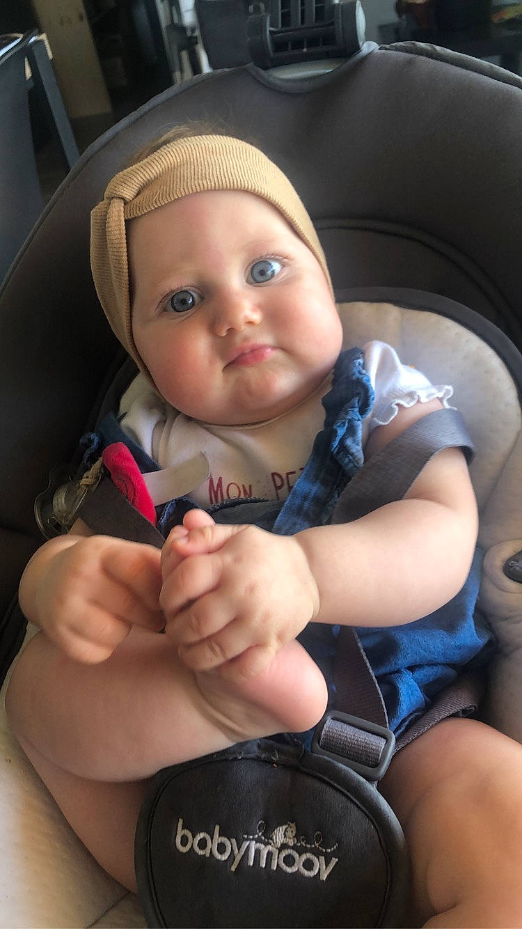 Oriane a rejoint le concours — aidez-le/la à gagner de superbes lots ! auto_part, baby, baby_carriage, baby_in_car_seat, car_seat, cheek, child, finger, hand, headwear, person, smile, thumb, toddler