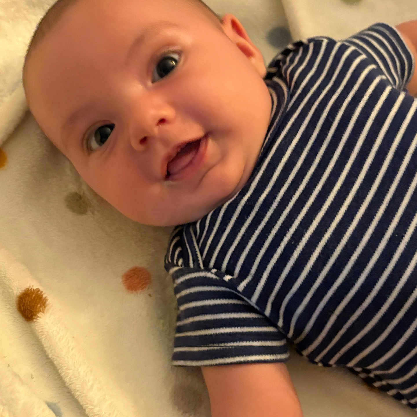 Emerson joined the competition — help win amazing prizes! adorable, arm, baby, blanket, child, closeup, comfortable, cute, eyes, face, happy, indoor, infant, lying_down, person, polka_dot, smile, soft_texture, striped_clothing, young