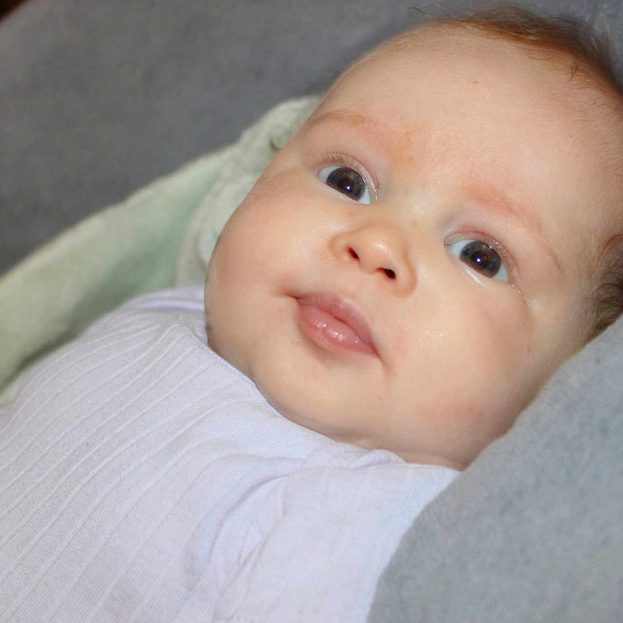 Valkyrie joined the competition — help win amazing prizes! baby, infant, child, portrait, face, eyes, wide_eyed, lying_down, blanket, clothing, white_shirt, soft_lighting, close_up, indoors, cozy, couch, head, skin, photography, adorable