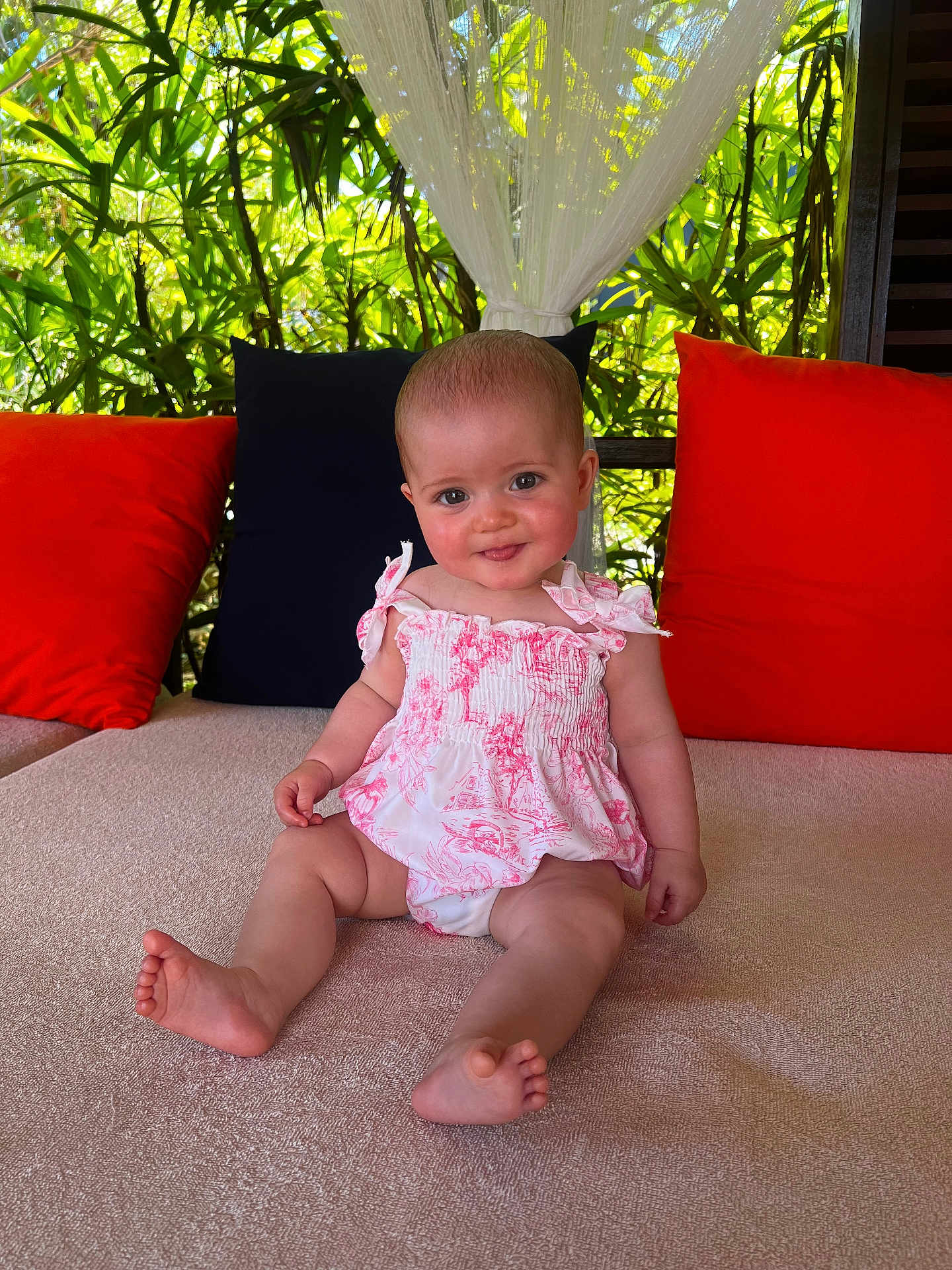Bonnie joined the competition — help win amazing prizes! baby, child, smiling, sitting, pink_clothing, orange_pillows, blue_pillow, cushion, outdoor, greenery, curtains, toddler, face, happy, barefoot, portrait, infant, sunlight, nature, relaxing